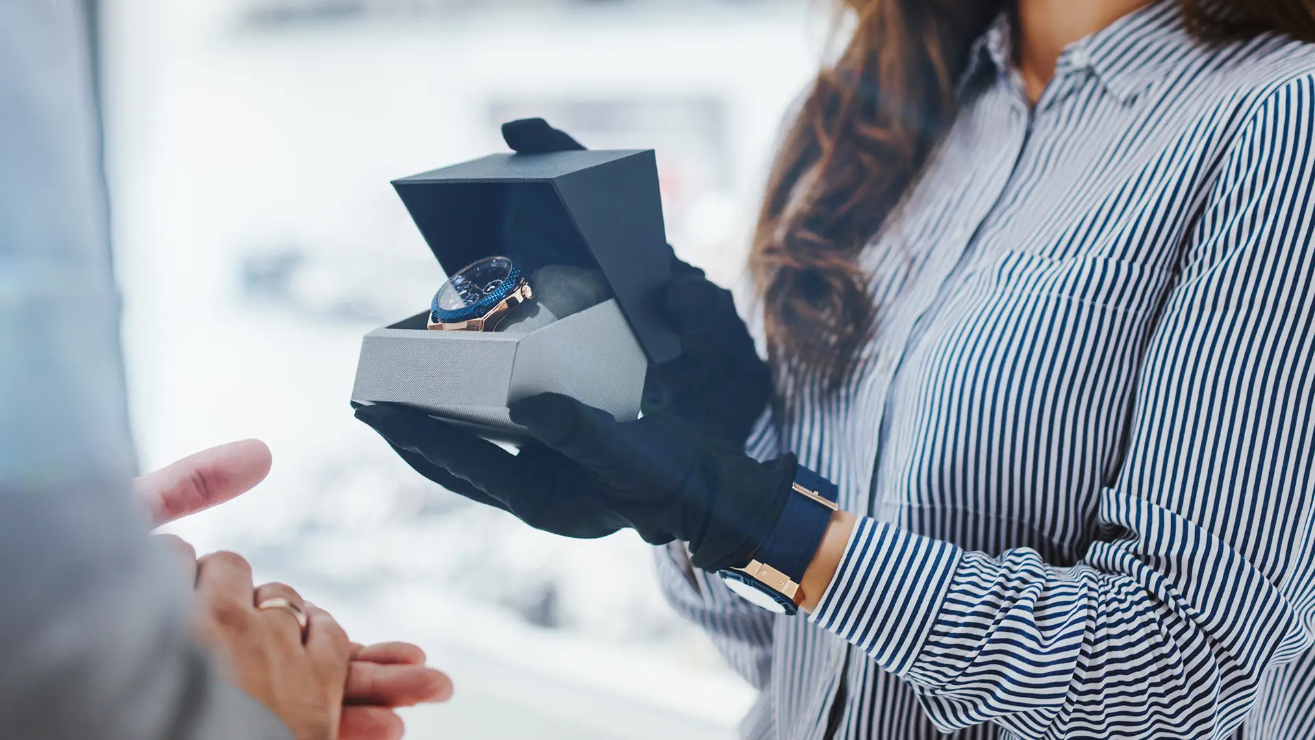 Verkäuferin präsentiert eine Uhr